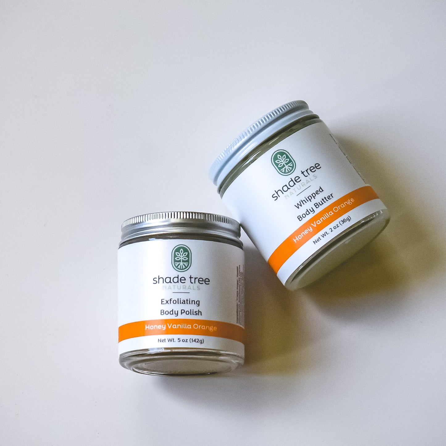 Two containers of 'shade tree' products on a white background
